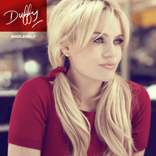 Image of a blonde woman wearing a red T-shirt with her hair in pigtails and with her arms drawn in to her sides. She is staring off-centre to her left and the background appears to have been blurred. In the left corner, the word "Duffy" is written in a red box in signature style. Below is the word "FLOP" in smaller writing.