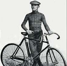 A man posing with a bike.