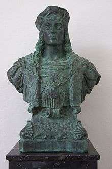 Bronze bust of man with long hair and a hat