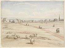 A watercolour showing the church in the distance with several buildings. Sheep are grazing in the foreground.