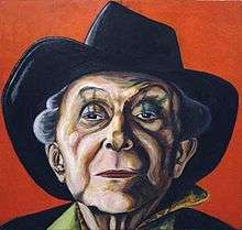 This colorful portrait focuses on Crisp's face (under his trademark fedora), but the viewer can still glimpse a stylish shirt collar. Crisp squints down his nose at the viewer through almond-shaped eyes. Green stripes extend from eyelid to eyebrow.
