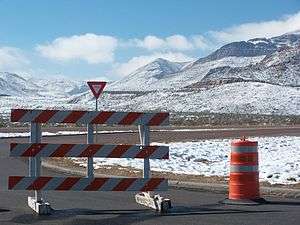 Image of barricades across Woodrow Bean Transmountain Drive with snow across surrounding Franklin Mountains.