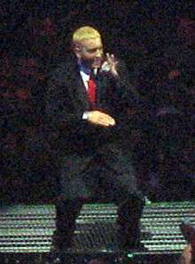 Eminem onstage, with blond hair and wearing a suit