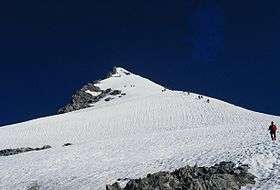 A snow-covered mountain against a clear deep blue sky