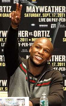 Mayweather smiling and flashing "V" for victory with his right hand