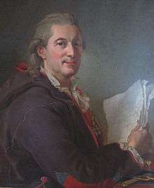 A man in his late 50s wearing a powdered 18th-century style wig. His body is facing to the right. His face has a resolute expression and is turned toward the viewer. His right arm is propped on a table with plotting tools and a book at the bottom of the painting and is holding up several white sheets of paper. He is wearing a large jacket or coat in a purple nuance with a red lingin and with red and blue designs on the sleeves and small of the back. The jacket is in the traditional style of the Sami people of northern Scandinavia.