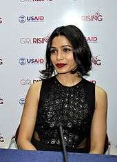 Freida Pinto is looking away from the camera.