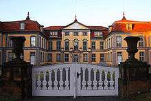 The symmetrical structure of Schloss Friedrichsthal, seen through the front gate to the property