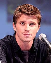 Garrett Hedlund in front of a microphone during a press conference.