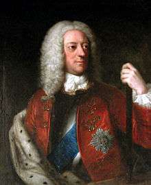 A half-length colour portrait of a man wearing a long wig.  Various emblems are apparent on his jacket, and his left hand holds a pole.