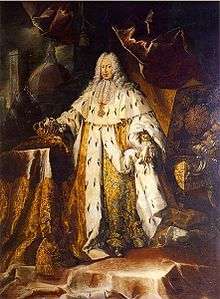 An elderly peri-wigged man is resplendent in gold, ermine-fringed coronation robes.