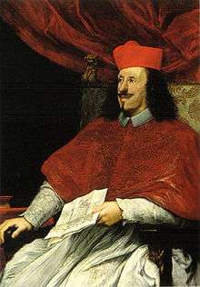 A black-haired, bearded man in his mid-thirties wears the garb of a Roman Catholic cardinal.