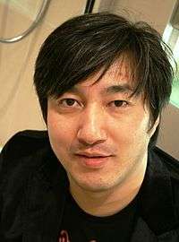 A head shot of a Japanese man in a black T-shirt.
