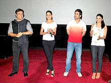 Govinda and three other people, standing on a red carpet