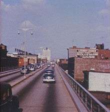 An elevated four lane freeway in an urban area as it appeared in 1954