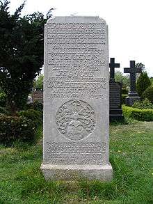 A tall tombstone with an inscription in Latin language and a coat of arms showing a whale and the goddess of fortune