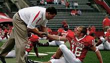 Photograph of Schiano interacting with a player during pre-game warmups