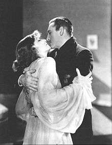Greta Garbo and Barrymore standing, in a close embace, about to kiss