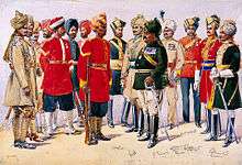 A painted illustration showing a group of men wearing various 19th Century military uniforms – some wearing sand-coloured tunics, some red and some black. All of the men are wearing turbans of various colours.