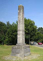 A column of stone stands on a square base.
