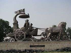 Photograph of a bronze chariot. The discourse of Krishna and Arjuna, in Kurukshetra has been captured in this photo.