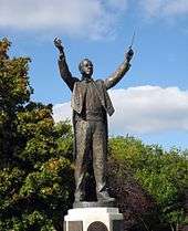 outdoor full length statue showing Holst conducting