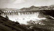 Front view of a dam releasing water through its spillways