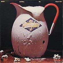 A pitcher of beer, labeled "David Bromberg Band", on a bar, with some popcorn