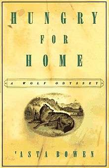 A yellow book cover, with the title, "Hungry for Home: A Wolf Odyssey", written in a prominent serif-font along the top and the author's name, 'Asta Bowen, at the bottom. Above the author's name, is an oval with a wolf lying in a grassy field with a forest visible behind it