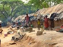 Hyderabad slum dwellers outside mud houses