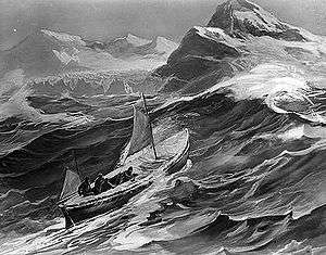 A small boat with two sails set climbs the steep side of a wave. In the background are the rocky tops of high cliffs and distant mountains