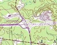 A topographic map showing a freeway coming in from the left and ending abruptly at a surface road running top to bottom. The freeway continues to the right as a dotted line
