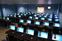 Dozens of bright blue computer screens in a large room.