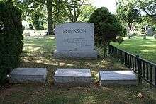 Three Robinson family gravestones are placed next to a larger family headstone with the quotation "A life is not important except in the impact it has on other lives", inscribed with Robinson's signature