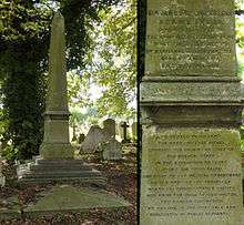 A granite obelisk, green from moss, in the shadow of a tree and surrounded by headstones