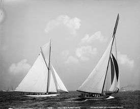 Black and white photograph of two yachts racing under full sail
