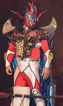 Picture of a masked Japanese wrestler wearing an elaborate red mask with horns.