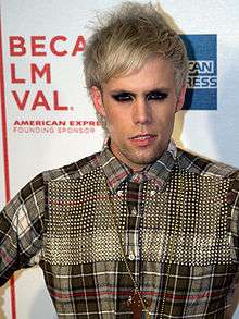 A shot of Justin Tranter, peering into a nearby camera.