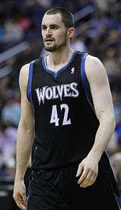 Kevin Love, bearded, in a black Timberwolves uniform with blue and white trim