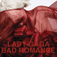 Upper bust of a blond woman. She has short cropped hair. Her body and her face is covered by a red translucent cloth with intricate wrappings in the front. Over the image the words "Lady Gaga" and "Bad Romance" are written in red capital letters.