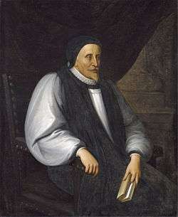 A solemn old white man clothed in Reformation-era clerical robes, seated and holding a book.