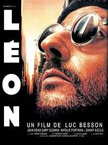 Picture of Jean Reno as Leon. He is bearded and wearing sunglasses looking upwards