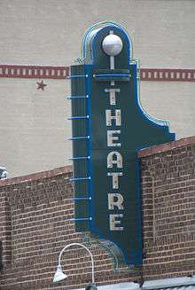 Photograph of an old theater sign on a rustic building.