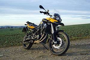 Black and yellow motorcycle parked on the edge of a field
