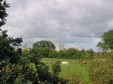 An English pastoral scene, with horses and a church in the background