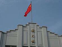 Picture of Longmen Building and Chinese Flag.