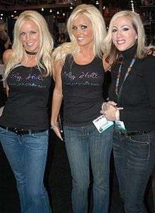 Two JC's Girls members, Lori Albee and Heather Veitch, both wearing a JC's Girls T-shirts and posing with Annie Lobert, founder of Hookers for Jesus, at the 2007 Adult Entertainment Expo