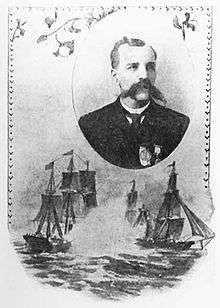Portrait of a man with a very wide mustache, wearing a jacket and tie with a medal pinned to the left breast. Around the portrait is decorative frame and a sketch of sailing ships.