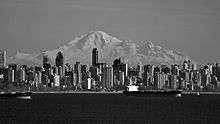 Black and white picture of the downtown Vancouver cityscape, a mountain in seen in the background.