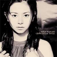 A slightly-sepia tinted image of Mai Kuraki, in front of a blurry background.